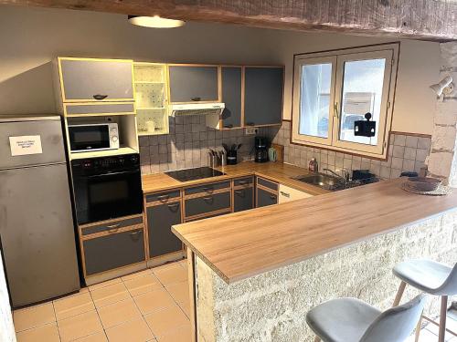 uma cozinha com utensílios de aço inoxidável e armários de madeira em Bel appartement proche du centre ville em Montpellier