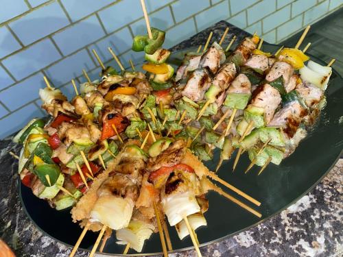 a plate with skewers of food on a table at Dolinka Lodge in Dzhergalan