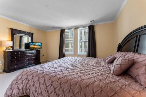 um quarto com uma cama, uma cómoda e uma televisão em Residence 203 At The Grand em Wildwood