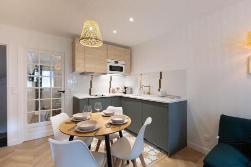 une cuisine avec une table et des chaises dans une pièce dans l'établissement Le Nid - City Center - Fontainebleau, à Fontainebleau