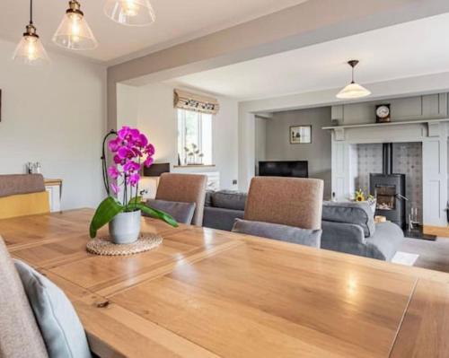 a dining room and living room with a wooden table at Stunning lodge in idyllic rural Herefordshire in Dorstone