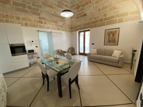 a living room with a glass table and a couch at Villa Anna - Suites & Events in Specchia
