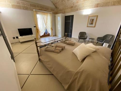 a large bed with pillows on it in a room at Villa Anna - Suites & Events in Specchia