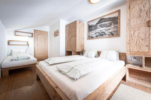 a bedroom with a large bed with white sheets at Weißnbachlhof in San Giovanni in Val Aurina