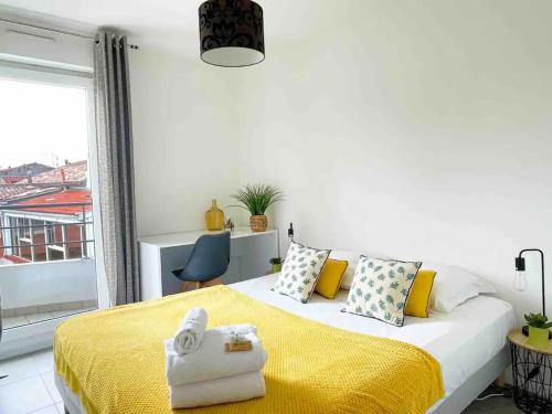 een slaapkamer met een groot bed en een gele deken bij Bara by Yumē in Toulouse
