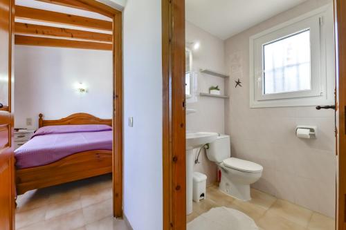 a bathroom with a bed and a toilet and a sink at Rafol - Casa adosada con piscina comunitaria y tenis comunitario in Calpe