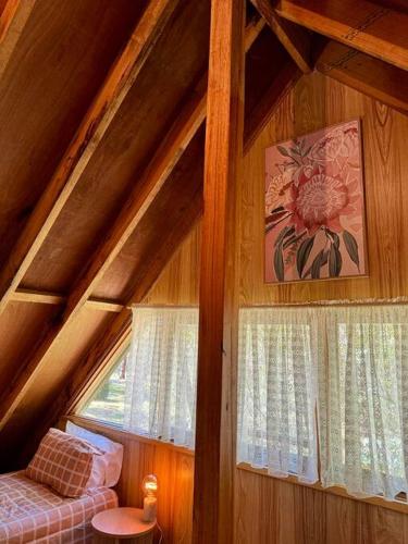 a attic room with a window and a bed at Tranquil getaway amidst nature in Icy Creek in Fumina