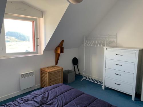 a bedroom with a bed and a dresser and a window at Charmant appartement à l'entrée de Sauzon in Sauzon
