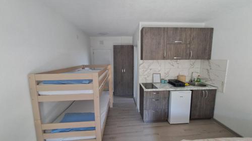 um pequeno quarto com um beliche e uma cozinha em Spasic Apartments Sutomore em Sutomore