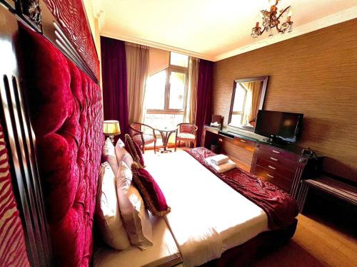 貝魯特的住宿－皇后套房酒店，一间卧室配有一张大床和电视