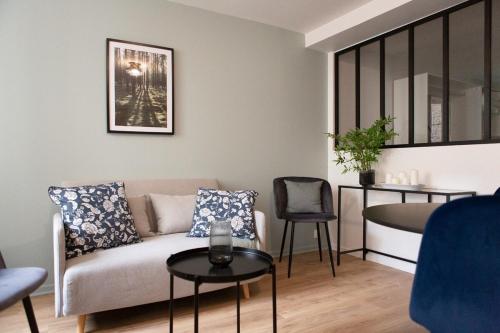 a living room with a couch and a table at Petit Moret - Cœur de ville in Moret-sur-Loing