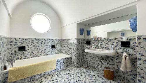 a bathroom with a tub and a sink and a mirror at Casa Colette in Anacapri