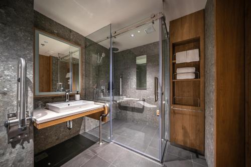 a bathroom with a sink and a shower at Sotetsu Grand Fresa Bangkok in Bangkok