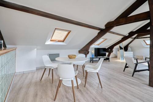une salle à manger avec une table et des chaises blanches dans l'établissement LE NID DE LA GLORIETTE Hyper centre NANTES WIFI, à Nantes
