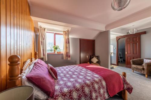 Un dormitorio con una cama grande y una ventana en The Bothy, Landrake en Saltash