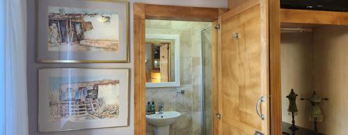 a bathroom with a sink and a toilet and a mirror at The Wooden Leg Guesthouse in Kleinmond