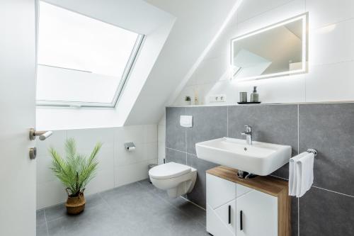 a bathroom with a sink and a toilet at Gemütliche Penthouse-Wohnung I Jacuzzi I Gasgrill in Rheda-Wiedenbrück