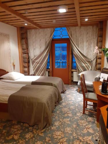 ハラマにあるPower Park Accommodationのベッドルーム1室(ベッド2台、椅子、窓付)