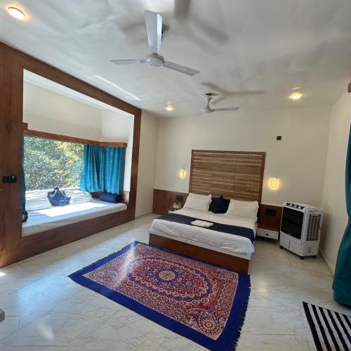 a bedroom with a bed and a large window at Brook Ville in Sasan Gir