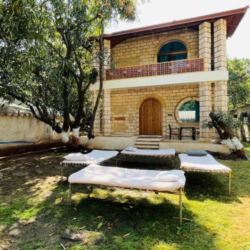 a house with four mattresses in front of it at Brook Ville in Sasan Gir