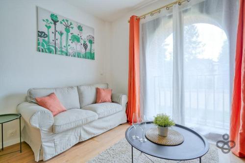 a living room with a couch and a table at La Halle Du Roi Parking Insead in Fontainebleau