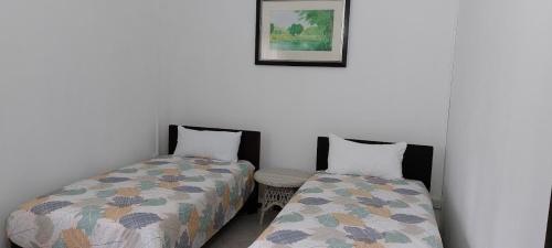 1 dormitorio con 2 camas y una foto en la pared en Lush Garden Villa with Sand Garden en Pointe aux Piments