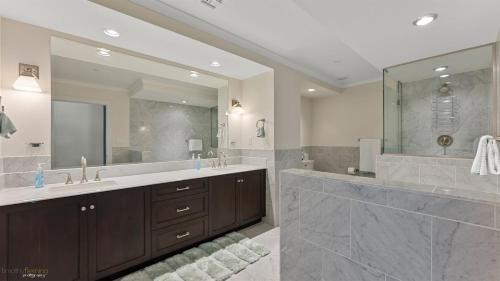 La salle de bains est pourvue de 2 lavabos et d'un grand miroir. dans l'établissement Residence 902 At The Grand, à Wildwood