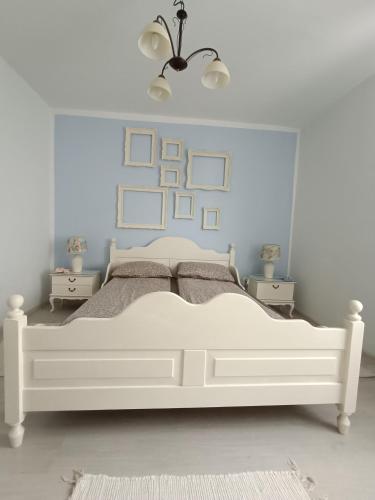 1 dormitorio con cama blanca y pared azul en Ingrid Residence, en Ocna-Mureşului