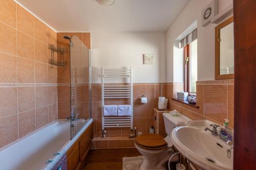 a bathroom with a tub and a toilet and a sink at Wheel Cottage, Landrake in Saltash