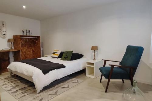 1 dormitorio con 1 cama y 1 silla azul en L'élégante, 2 pers, centre ville Soyaux, en Soyaux