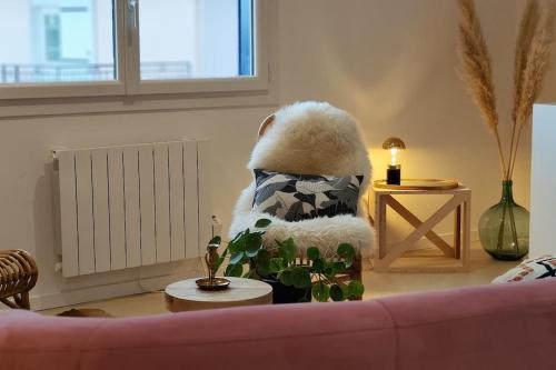 uma sala de estar com um sofá e uma planta em L'élégante, 2 pers, centre ville Soyaux em Soyaux