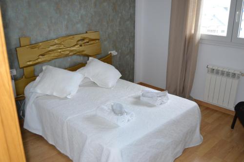 ein Schlafzimmer mit einem weißen Bett mit zwei Gläsern darauf in der Unterkunft Matias Lopez 78 in Sarria