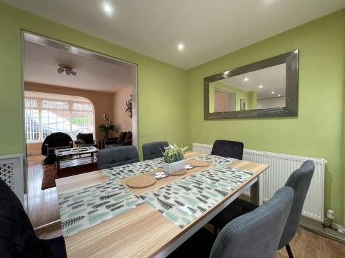 een eetkamer met een tafel met stoelen en een spiegel bij Stylish 3 Bedroom House Basildon/Essex Upto 5 Guests in Basildon