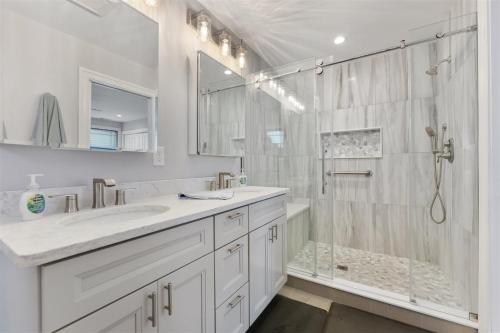 ein weißes Bad mit einer Dusche und einem Waschbecken in der Unterkunft 303 E Nashville Ave in Wildwood Crest