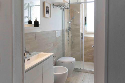 Un baño con inodoro, lavabo y ducha. en ROSSENA HOME tranquillo appartamento, con giardino, vicino al centro ed all'Ospedale Santa Maria Nuova SMN, en Reggio Emilia
