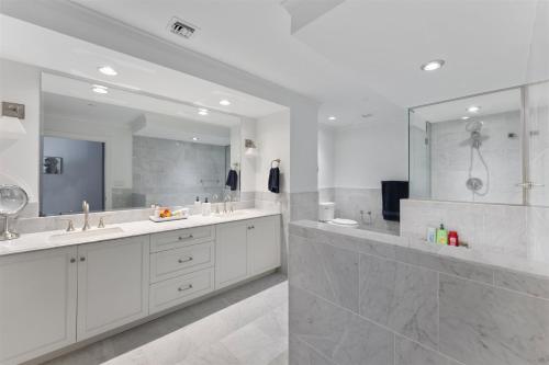 a white bathroom with two sinks and a shower at Residence 102 At The Grand in Wildwood