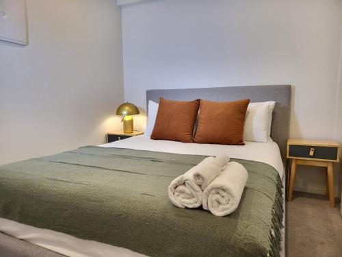 1 dormitorio con 1 cama con toallas en Sky Stars business Aparment en Auckland