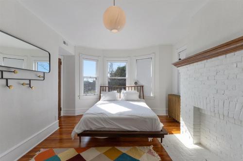 a white bedroom with a bed and a brick wall at 109 W Magnolia Ave in Wildwood