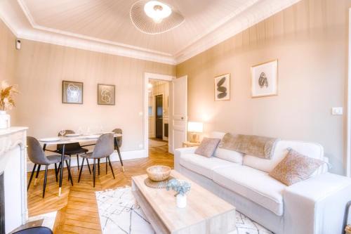 un salon avec un canapé blanc et une table dans l'établissement Le France - Les Jardins du Lys - Idéal Insead, à Fontainebleau