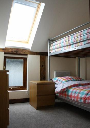 a bedroom with two bunk beds and a window at The Hayloft at Carpenters Farm in Colchester