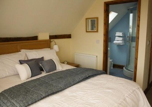 a bedroom with a large bed and a bathroom at The Hayloft at Carpenters Farm in Colchester