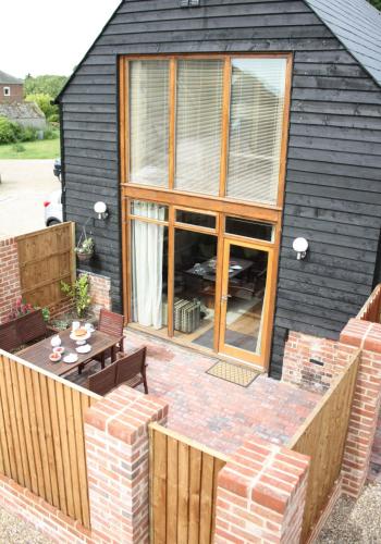 a backyard patio with a table and chairs at The Hayloft at Carpenters Farm in Colchester