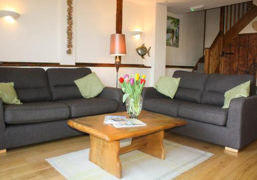a living room with two couches and a coffee table at The Hayloft at Carpenters Farm in Colchester