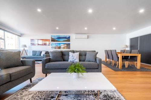 a living room with two couches and a table at Central & Modern Inner City Apartment with Wi-Fi in Launceston