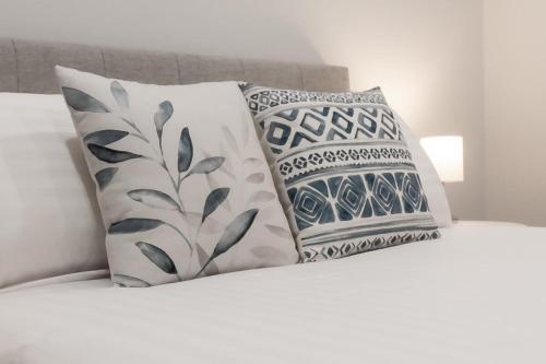 un grupo de almohadas sentado encima de una cama en Central & Modern Inner City Apartment with Wi-Fi, en Launceston