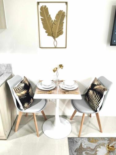 a dining room with a table and two chairs at Goldentel at Inspiria Condo Davao City in Davao City