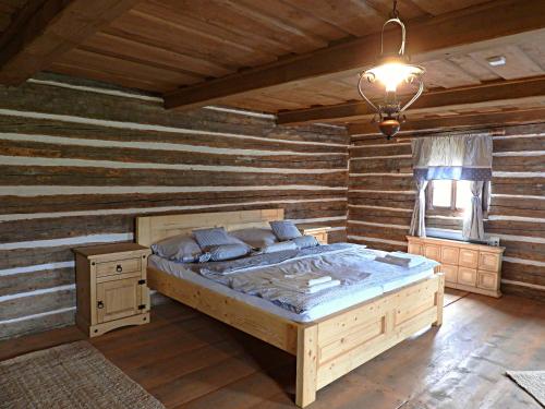 ein Schlafzimmer mit einem Bett in einem Zimmer mit Holzwänden in der Unterkunft Zoopark Chomutov in Chomutov
