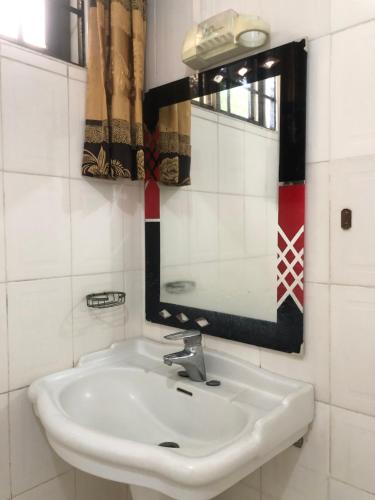 y baño con lavabo blanco y espejo. en Jambo hostel tz, en Dar es Salaam