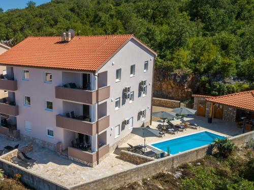 an aerial view of a building with a swimming pool at House CAPRI with heated pool and sea view in Klimno