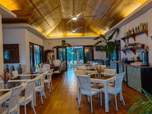 a restaurant with tables and chairs and a bar at Villas by Eco Hotels in Mataasnakahoy